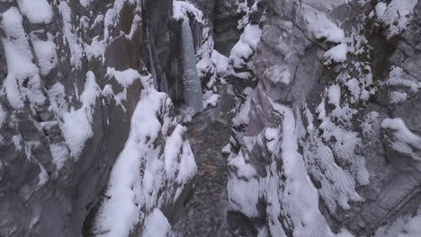 Ice-cold-clear-river-in-bottom-of-deep-narrow-stone-canyon-in-snow