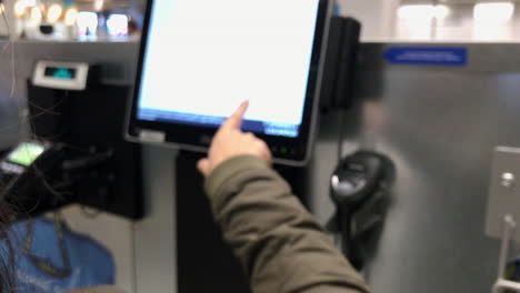borrosa: una mujer opera un panel de caja registradora de autoservicio