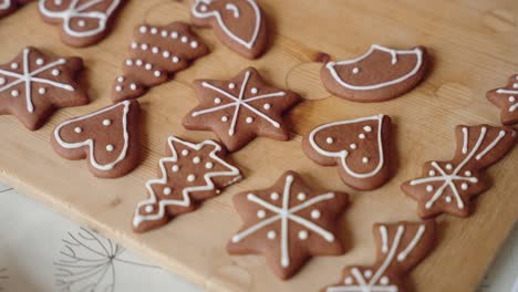 decorating gingerbread cookies for christmas, closeup macro shot making handmade festive new year sweets and cookies with white glaze icing