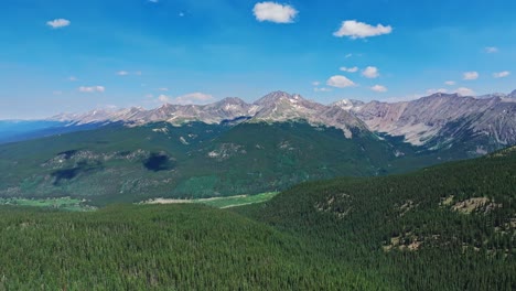 aerial over the trees and hills of cottonwood pass with the rocky mountains in the background, colorado, usa