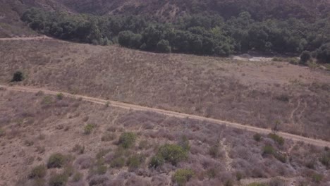 View-from-a-drone-flying-over-to-a-field-to-the-forest-in-front-of-the-mountain-in-mexico