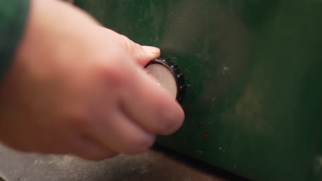 hand turning the on-off dial on a portable propane stove