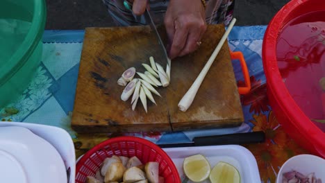 vrouw die uien snijdt voor gebruik in traditionele tom yam kung-soep