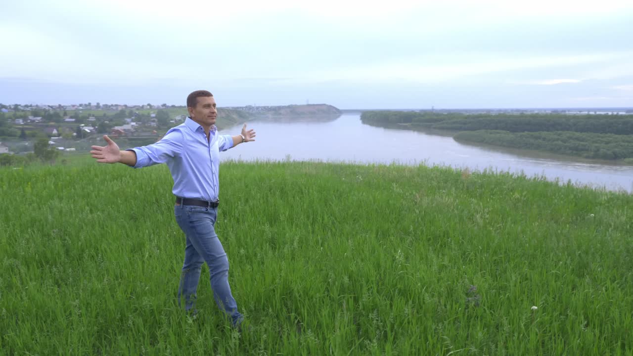 Man enjoying the view of a river from a hill