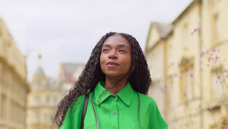 Female-Tourist-With-Camera-On-Vacation-In-Oxford-UK-Exploring-City-Walking-Along-Broad-Street-Taking-Photos