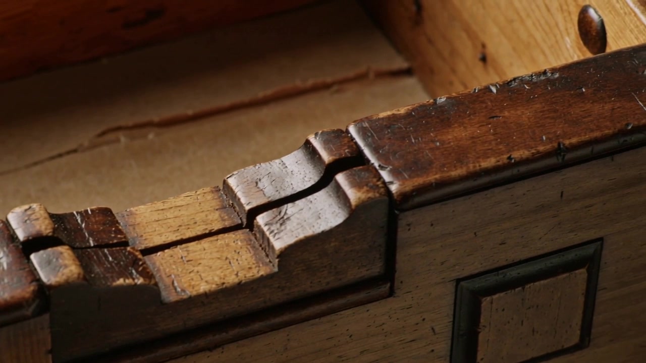 Sliding carved wooden wedge shifting along groove on chest top, frame sequence revealing peg, screw