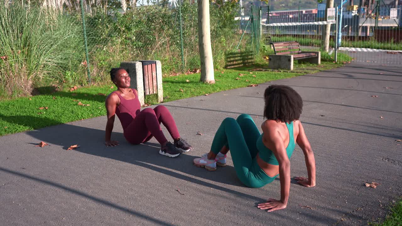 Two women exercising outdoors in a park