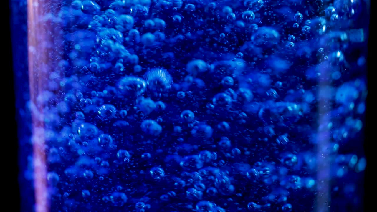 유리잔에서 거품이 나는 파란색 액체
