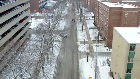 Eine-Drohnenaufnahme-Aus-Der-Luft,-Die-Sich-Rückwärts-Bewegt-Und-Dabei-Langsam-Nach-Oben-Schwenkt,-Um-Die-Landschaft-Einer-Stadt-Tagsüber-Im-Winter-Zu-Zeigen