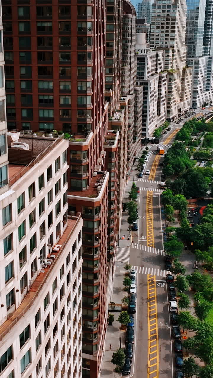 Drone footage close to the buildings at waterfront of Hudson River. Top view on the highway full of cars. New York from top. Vertical video