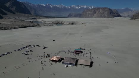 Drone-shot-of-the-jeep-rally-in-the-sarfaranga-desert-with-a-view-of-high-mountains