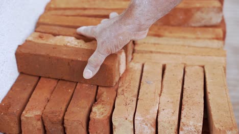 hand grabbing bricks for building wall,. close-up