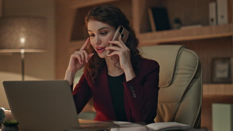 remote manager calling client looking laptop in dark office desk close up.