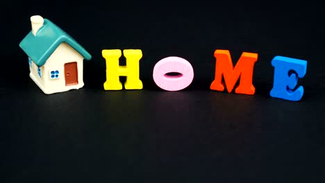 real estate concept. decorative letters forming word home with house on black background