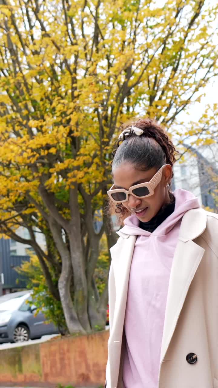 Donna con occhiali da sole alla moda e abbigliamento autunnale