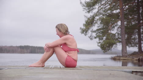 Mujer-Llorando-En-Traje-De-Baño-En-Un-Pontón-Después-De-Una-Emotiva-Sesión-De-Baño-De-Hielo-En-El-Lago