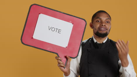 Professional-waiter-showing-a-message-to-vote-on-speech-bubble