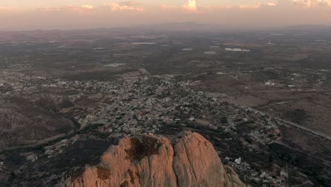 Flug-über-Peña-De-Bernal-Mit-Der-Stadt-Bernal-Bei-Sonnenuntergang-In-Querétaro,-Mexiko-–-13-Wunder-Mexikos