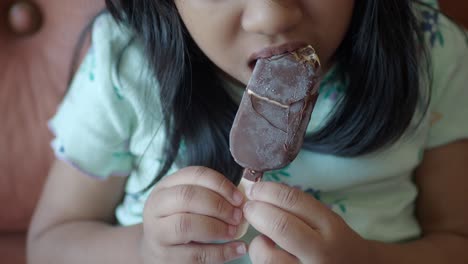 una niña disfrutando de un helado de chocolate