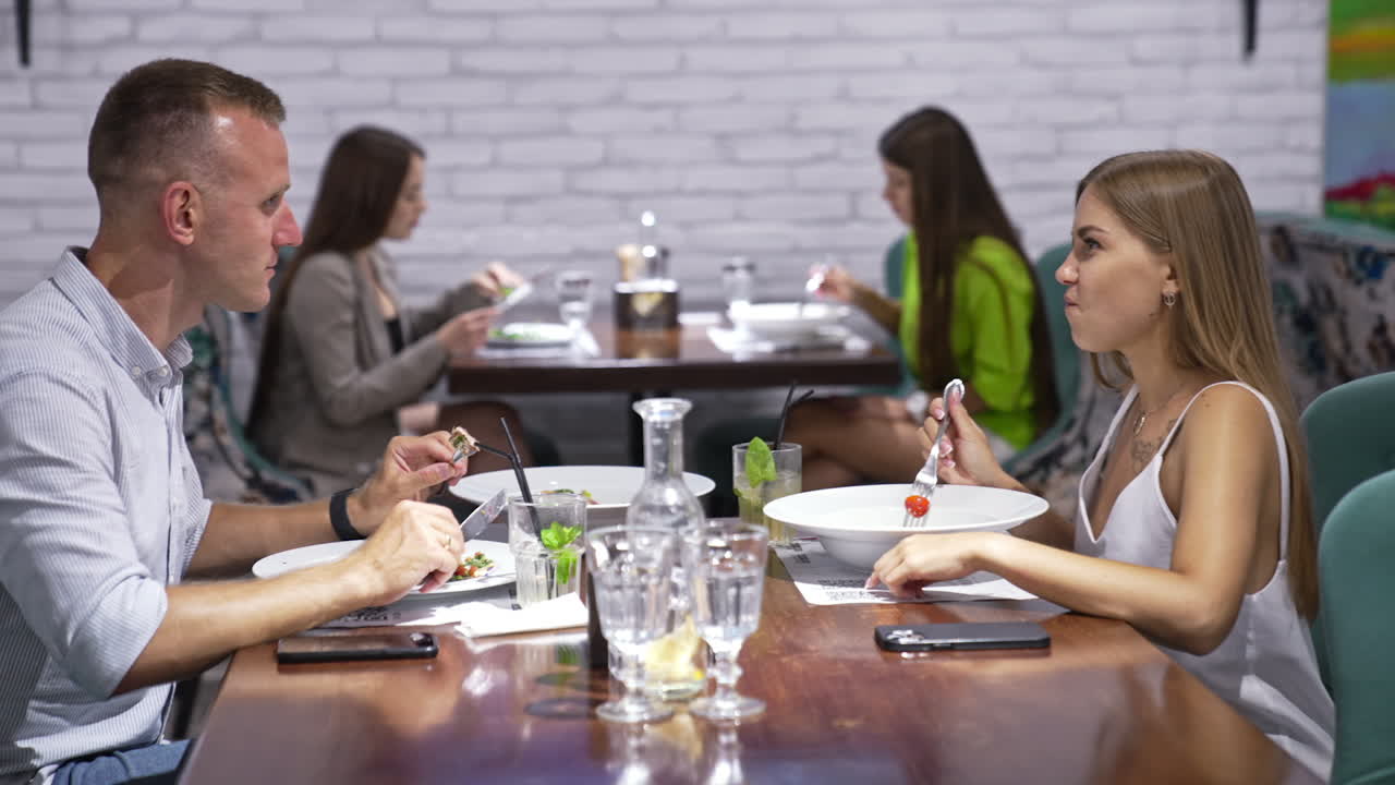 Couple and group of people dining at a restaurant