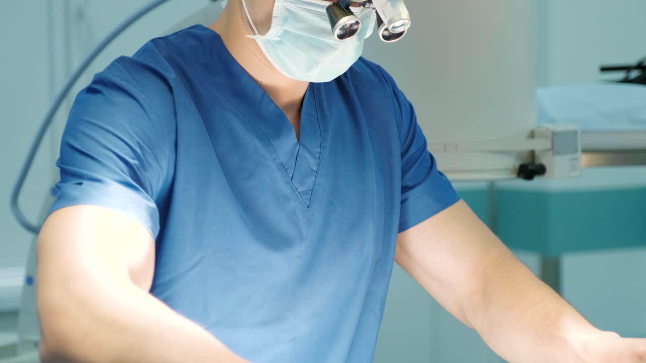 el cirujano mira a través de un microscopio móvil