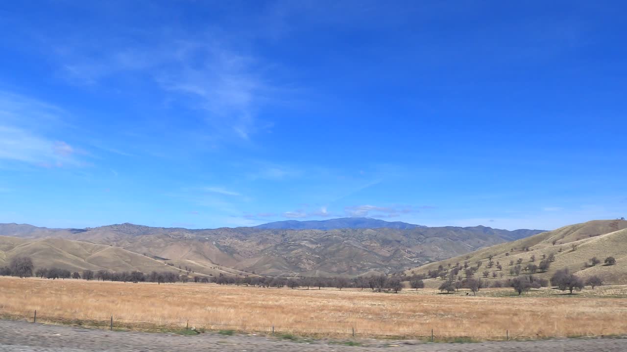 언덕, 산, 나무, 탁 트인 초원이 있는 그림 같은 시골을 따라 운전 - 승객의 관점