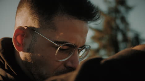 slow motion close-up of a caucasian male wearing glasses capturing a photo