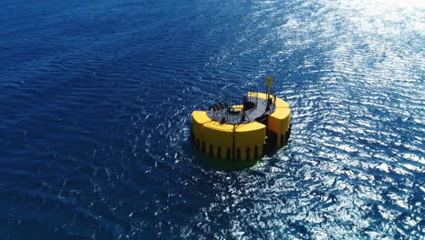 yellow mooring buoy in deep blue caribbean ocean, small waves and wind ripples, drone tilt down