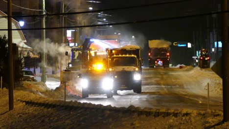 industrial snowblower clearing snow off city street, chute spray snow in truck