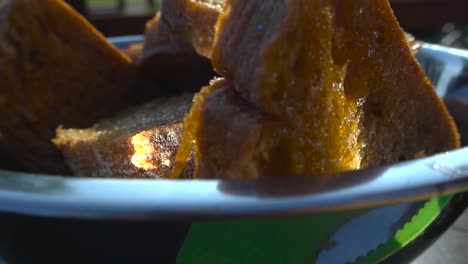 gorgeous closeup or close up footage gliding over cut slices of ciabatta white bread covered in flower and video reaches a bowl where those slices are covered in extra virgin golden olive oil, cooking