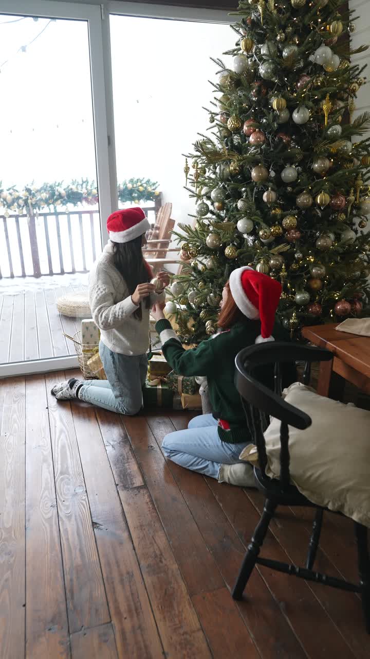 dos amigos decorando un árbol de navidad
