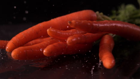 bunch of carrots falling on black background