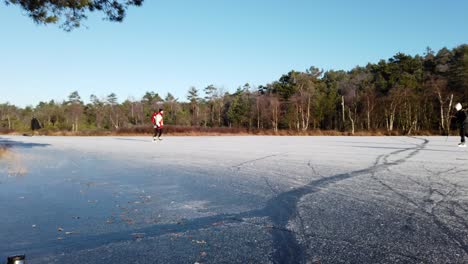 Schlittschuhläufer-Auf-Einem-Zugefrorenen-See,-Der-Im-Winter-Mit-Eis-Und-Schnee-Bedeckt-Ist