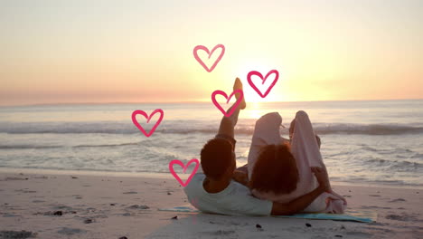 animation of hearts moving over diverse couple in love embracing on beach in summer