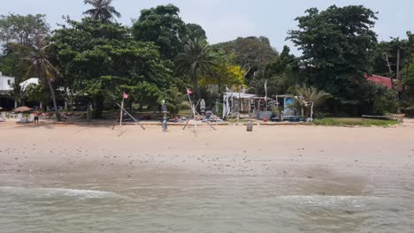 Aerial-View-Of-Ao-Kao-Beach-With-Sticks-On-Beach-With-Flags-Waving-In-Wind