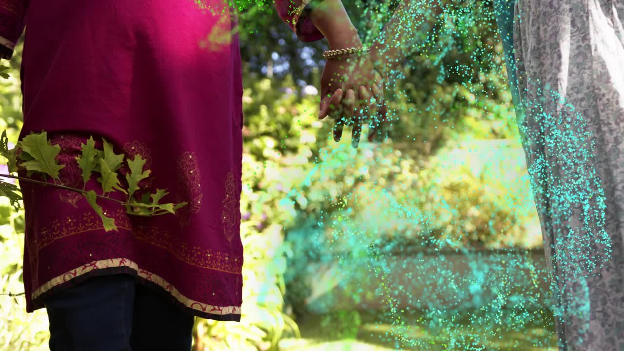 Two women holding hands walking sunlit path, teal swirl emerging at feet, wrapping hands for health