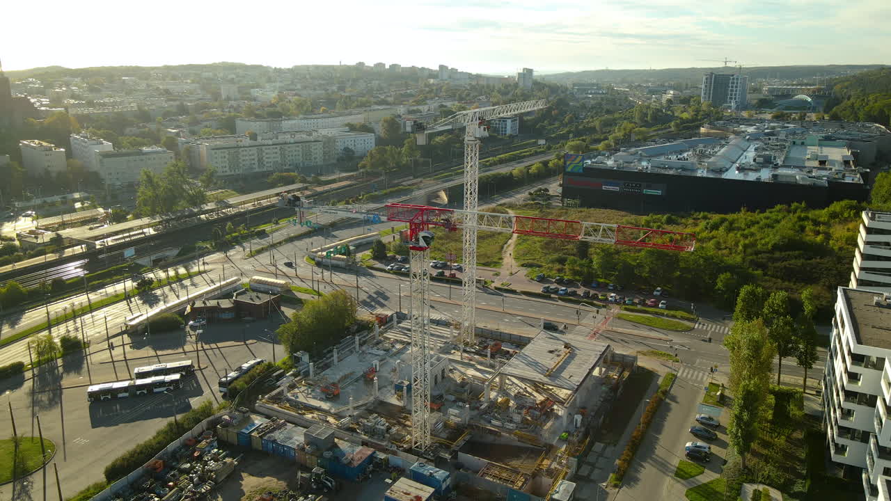 dos grúas torre en el sitio de construcción cerca del centro comercial riviera center en gdynia, voivodato de pomerania, polonia en un día soleado