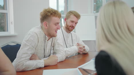 business-meeting-in-modern-company-young-handsome-men-communicating-and-discussing-in-conference