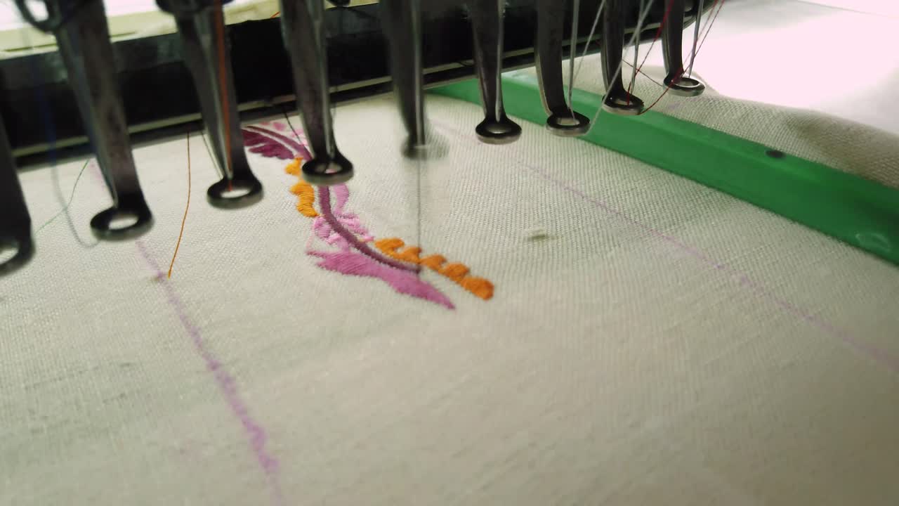 오렌지, 핑크, 블랙의 복잡한 꽃무늬를 재봉하는 현대적인 자수기