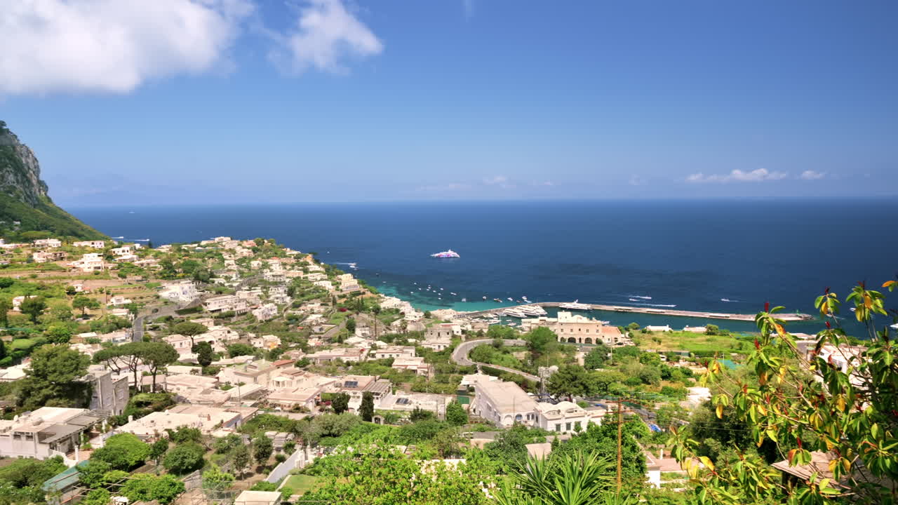 Paisagem urbana de Capri, Itália. Fileiras de edifícios residenciais, costa do Mar Tirreno, vegetação e montanha. Vista de uma colina