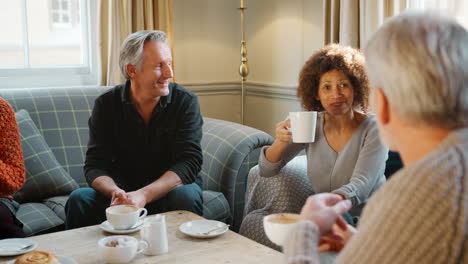group of middle aged friends meeting around table in coffee shop