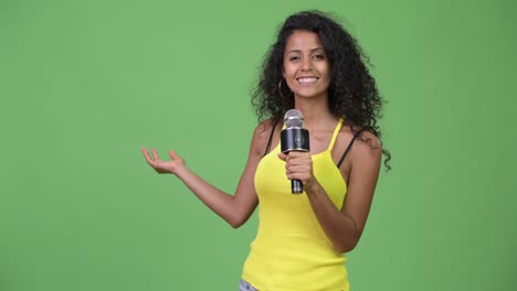 young beautiful hispanic woman using microphone