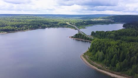 aerial view of a lake, forest, and road