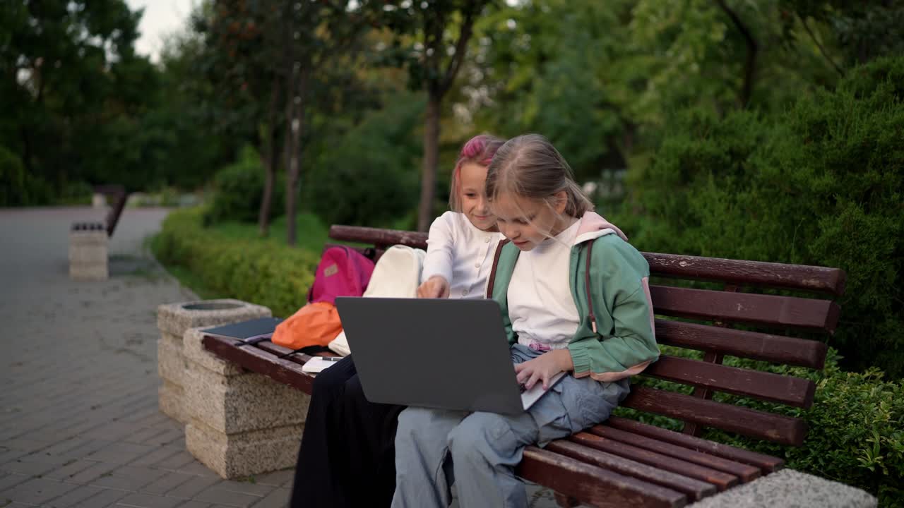 dos chicas estudiando juntas en un banco del parque