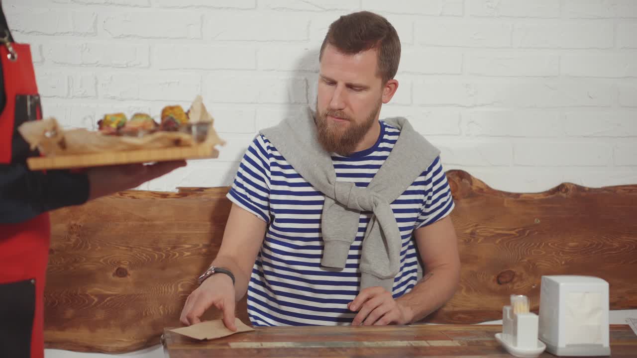 camarero sirviendo comida a un cliente en un restaurante