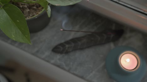 fumar incienso y una vela relajante junto a la ventana de la sala de estar, ambiente aromático para el yoga y la meditación