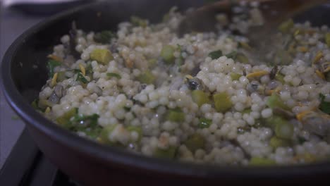 mixing a hot pan of vegetarian couscous