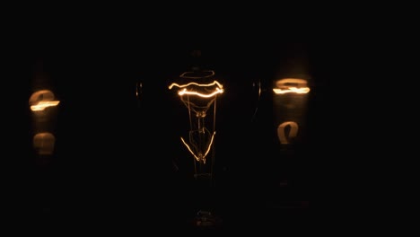 primer plano de una espiral de una lámpara incandescente. reflejos bailando, espirales en los espejos.