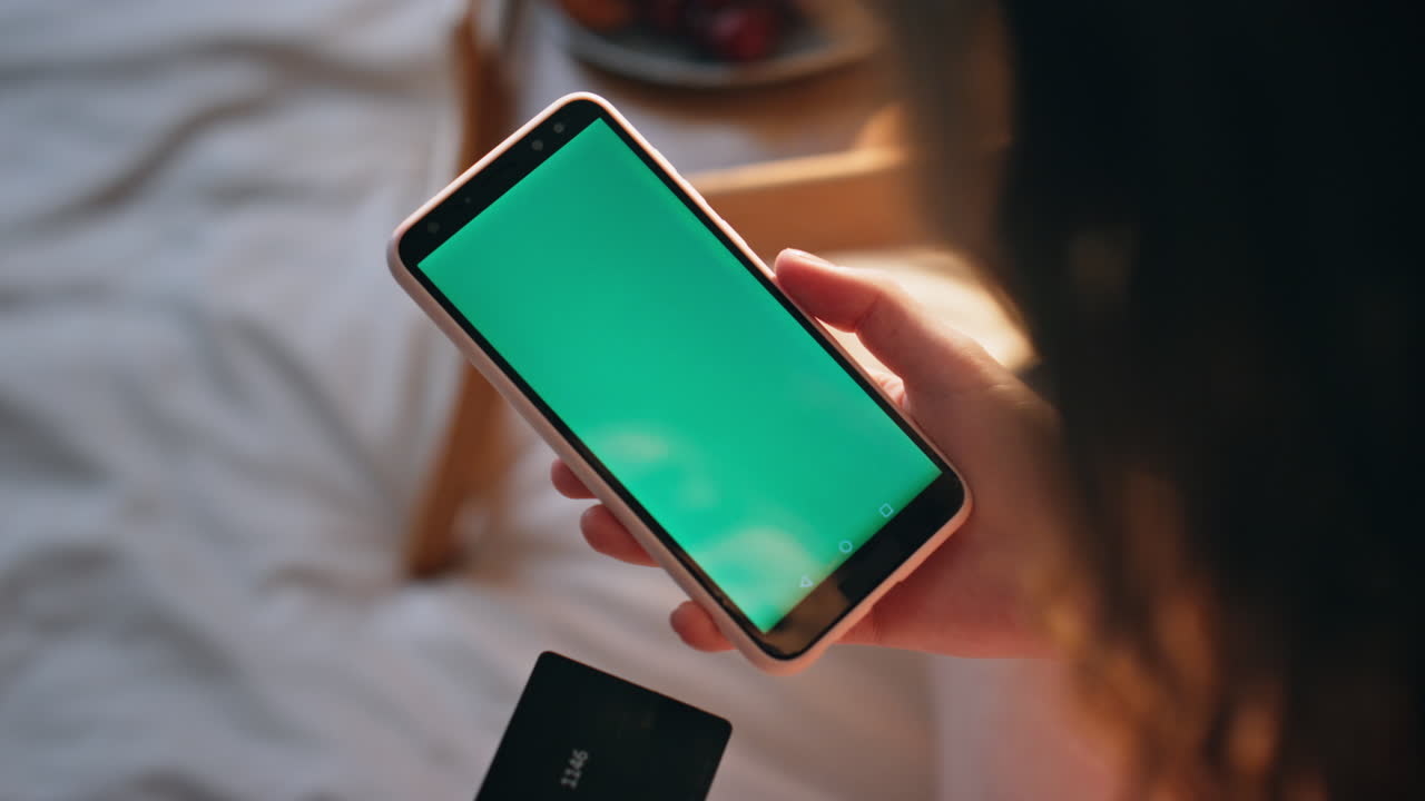 Hands hold chromakey smartphone at home closeup. Girl customer use credit card