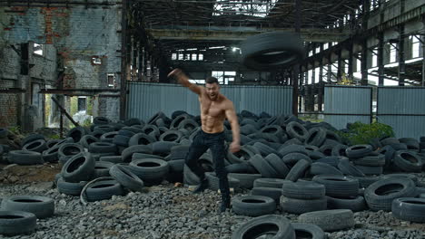 muscular man throwing tire. young muscular man working out with tire